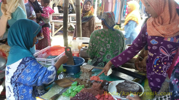 Asyarotun sedang melayani pembeli jajan tradisional di Pasar Tirem Enggal Dukun Gresik. (Foto: Linda/mg2/kabargresik.com)