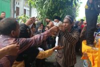 Kirab Tumpeng Bandeng di Desa Tambakberas Gresik bagikan ribuan bandeng gratis kepada warga luar desa dengan meriah.