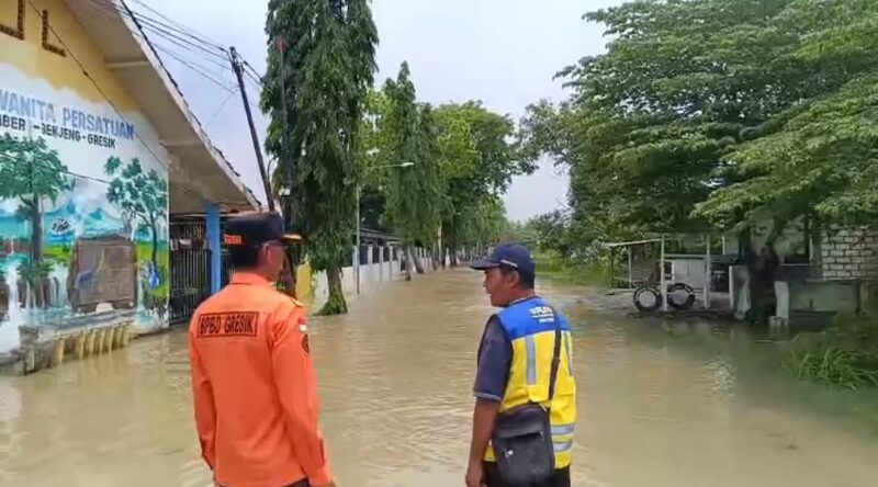 Hujan deras sebabkan Sungai Kedungpring meluap dan merendam Desa Deliksumber, Benjeng. BPBD Gresik lakukan penanganan cepat di lokasi.